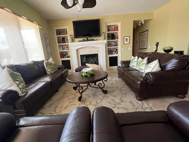 a living room with furniture a fireplace and a flat screen tv