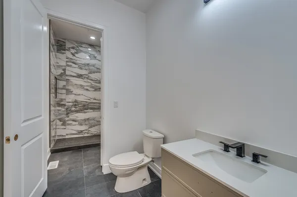 a bathroom with a sink a toilet and shower