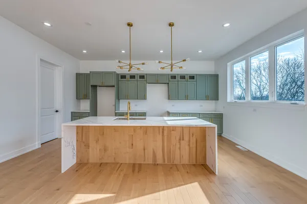 a view of kitchen with stainless steel appliances granite countertop cabinets and wooden floor