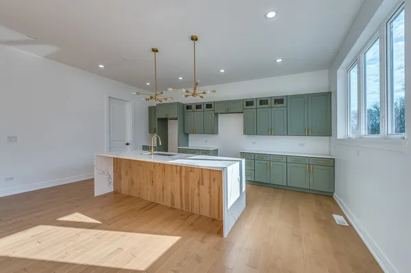 a kitchen with kitchen island a sink stainless steel appliances and cabinets