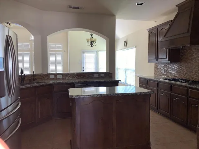 a kitchen with stainless steel appliances granite countertop a sink a stove and a refrigerator
