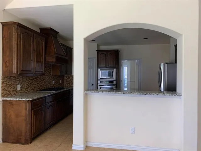 a kitchen with stainless steel appliances granite countertop a stove and a refrigerator