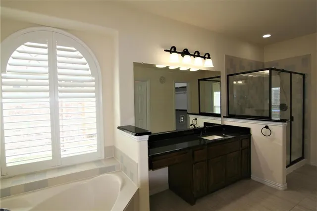 a bathroom with a tub sink and mirror