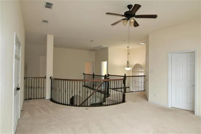 a view of a hallway with a chandelier and chandelier fan
