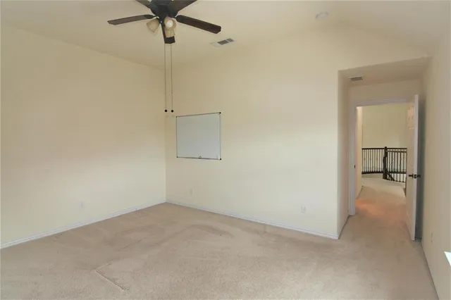 a view of a room with a ceiling fan and a rug