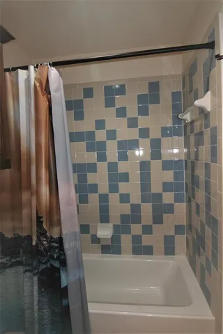 a bathroom with a bathtub and a shower