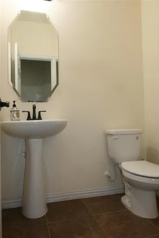 a bathroom with a sink toilet and mirror