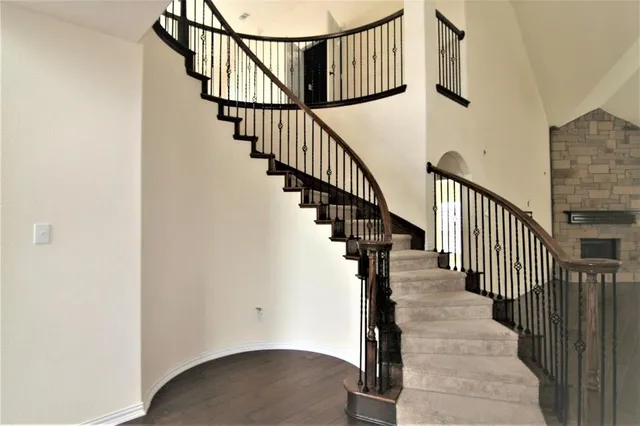 a view of staircase with wooden floor and white walls
