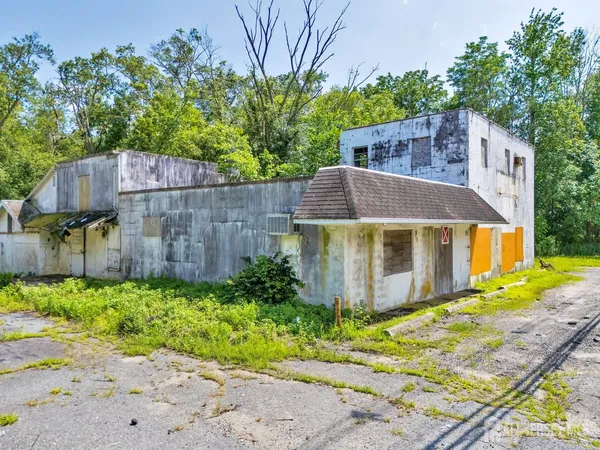 a front view of a house with a yard and trees
