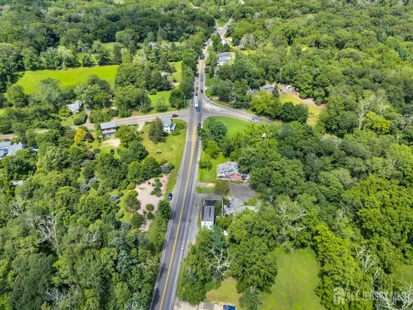 an aerial view of residential houses with outdoor space and trees