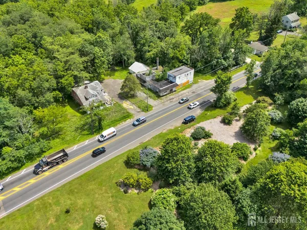 an aerial view of a house with a yard and large tree