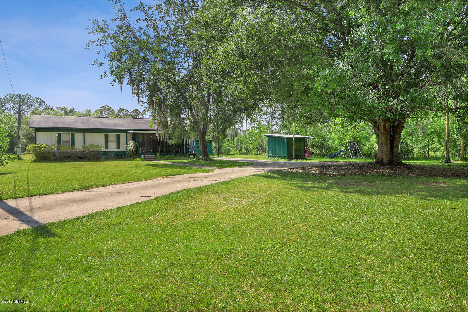 986 Bea Lane Jacksonville, FL 32220 - Photo 30 of 42 a view of a house with a big yard potted plants and large trees