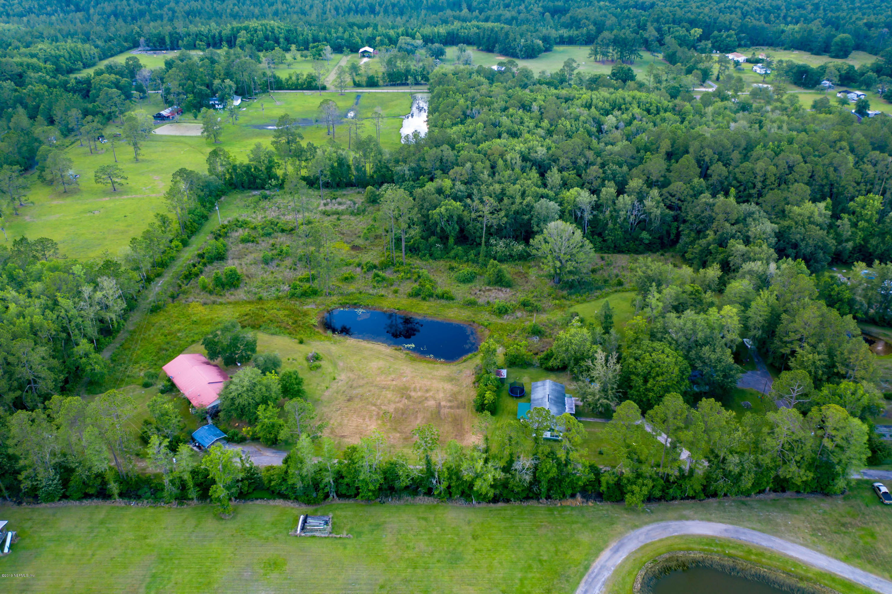 986 Bea Lane Jacksonville, FL 32220 - Photo 3 of 42 a view of a lake with a yard and large trees
