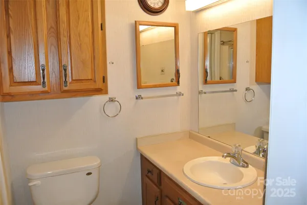 a bathroom with a granite countertop sink a toilet and a mirror