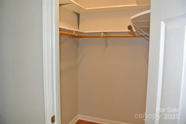 a view of walk in closet with empty racks