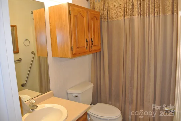 a white toilet sitting next to a shower curtain