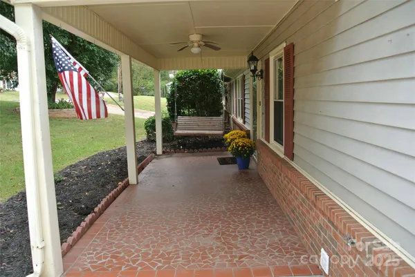 a view of a porch with furniture and a yard