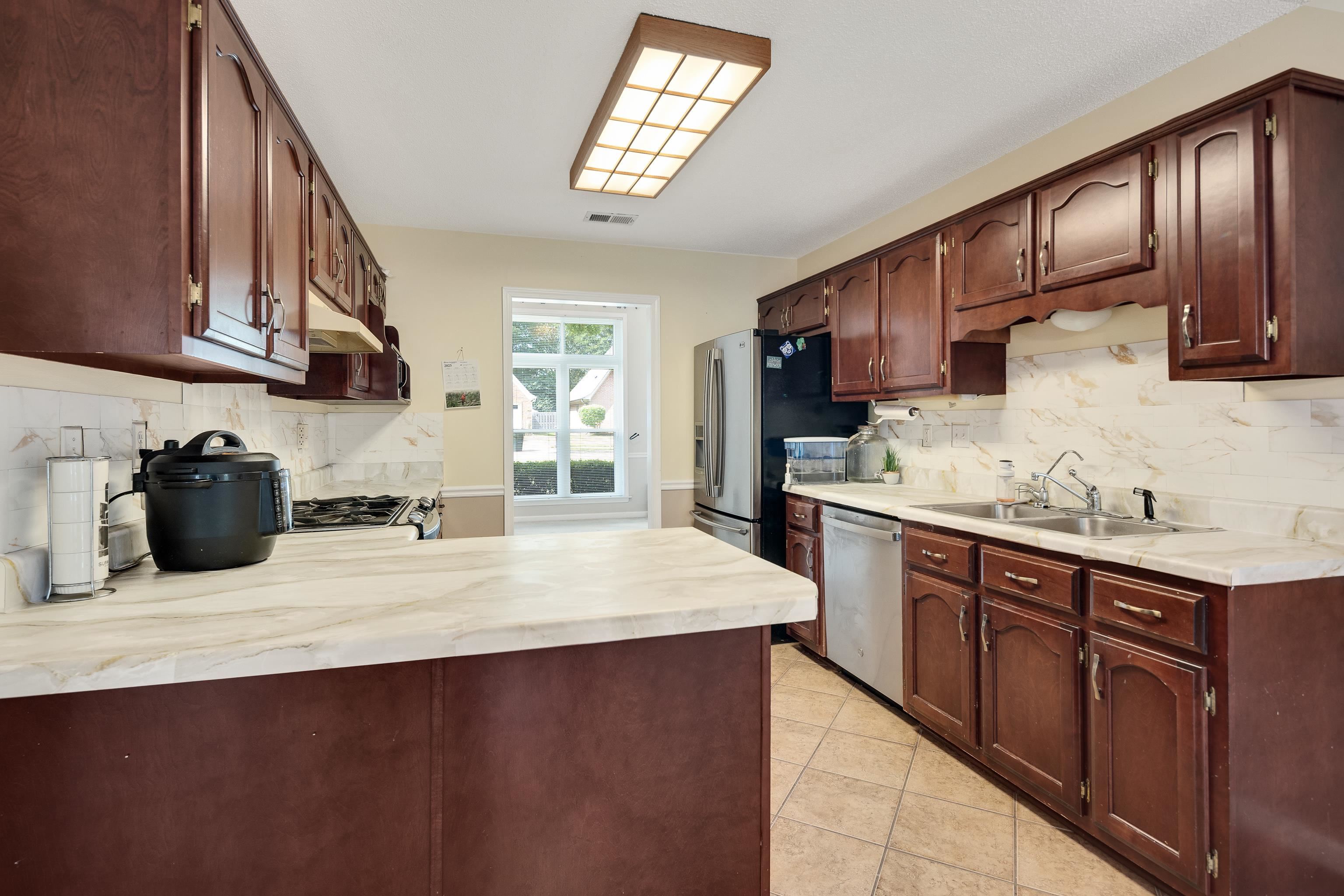 954 Wildbird Cove Collierville, TN 38017 - Photo 11 of 32 a kitchen with stainless steel appliances granite countertop a sink stove and cabinets