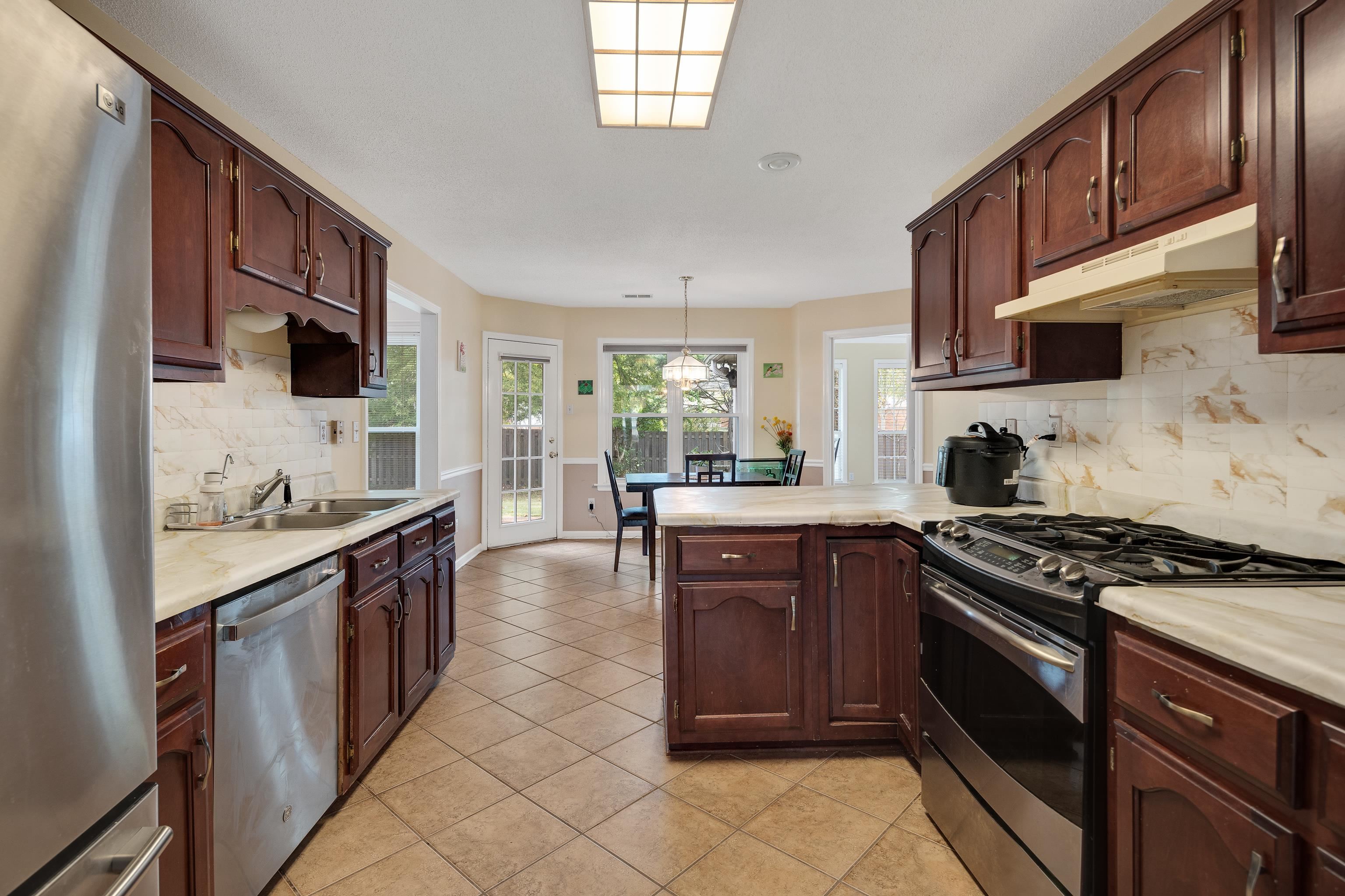 954 Wildbird Cove Collierville, TN 38017 - Photo 12 of 32 a kitchen with stainless steel appliances granite countertop a stove top oven a sink dishwasher a refrigerator and a cabinets