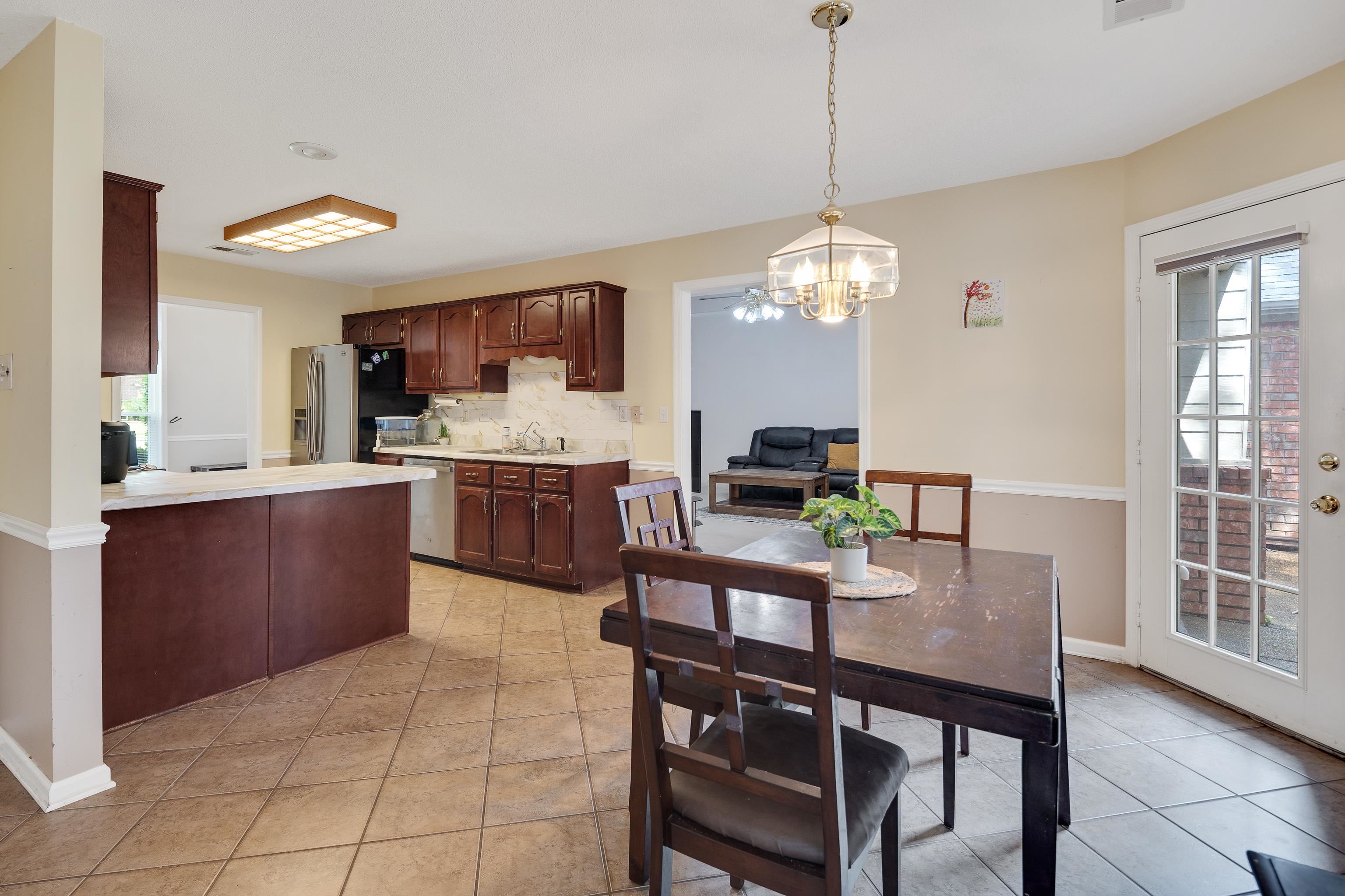 954 Wildbird Cove Collierville, TN 38017 - Photo 14 of 32 a kitchen with a dining table chairs and cabinets