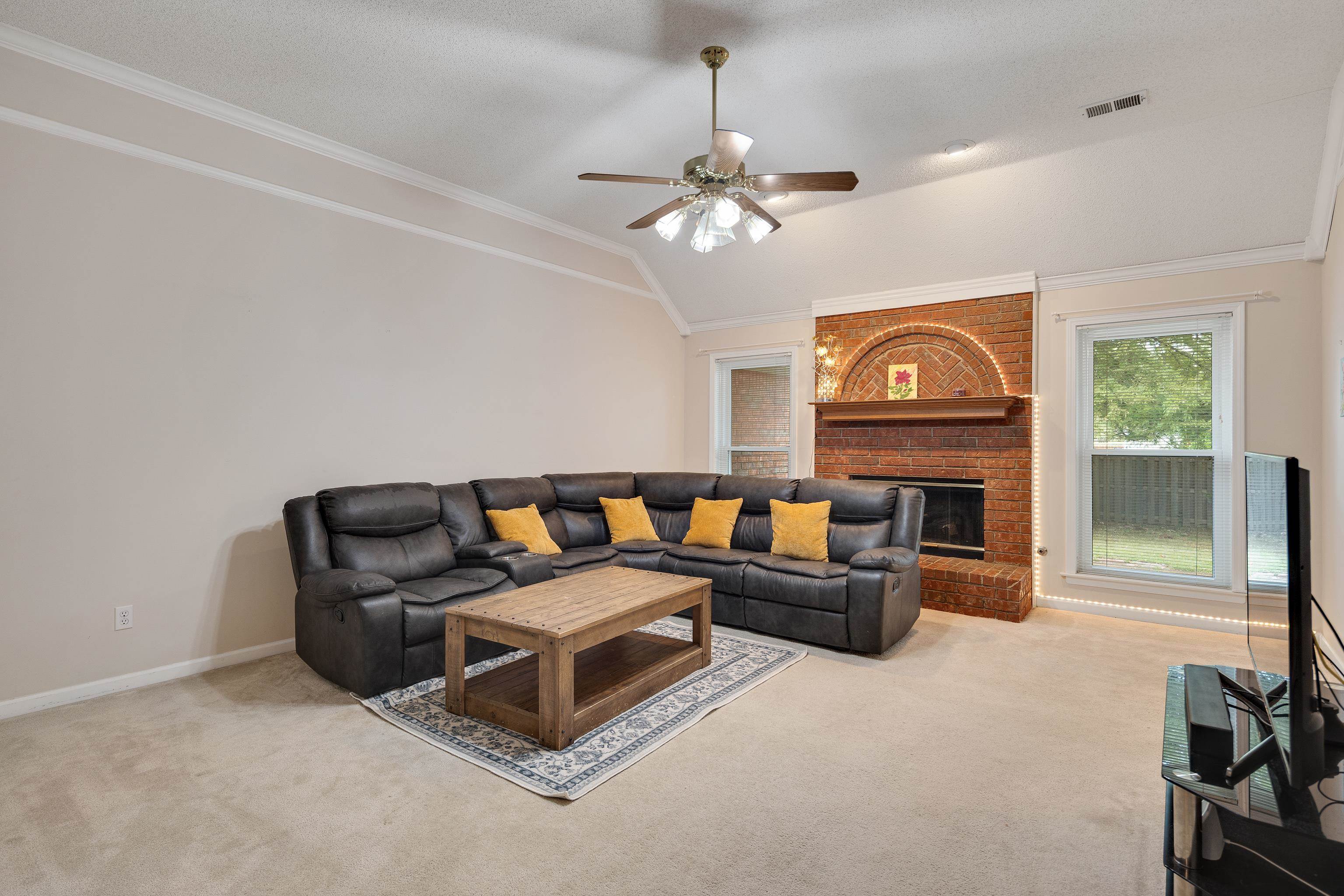 954 Wildbird Cove Collierville, TN 38017 - Photo 7 of 32 a living room with furniture a fireplace and a flat screen tv