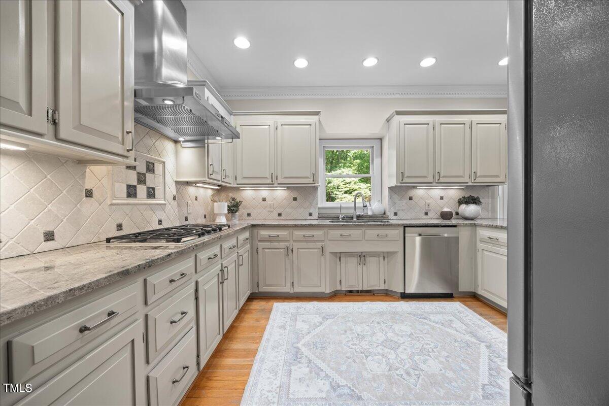 10036 Old Warden Road Raleigh, NC 27615 - Photo 15 of 42 a kitchen with kitchen island granite countertop appliances cabinets and a sink