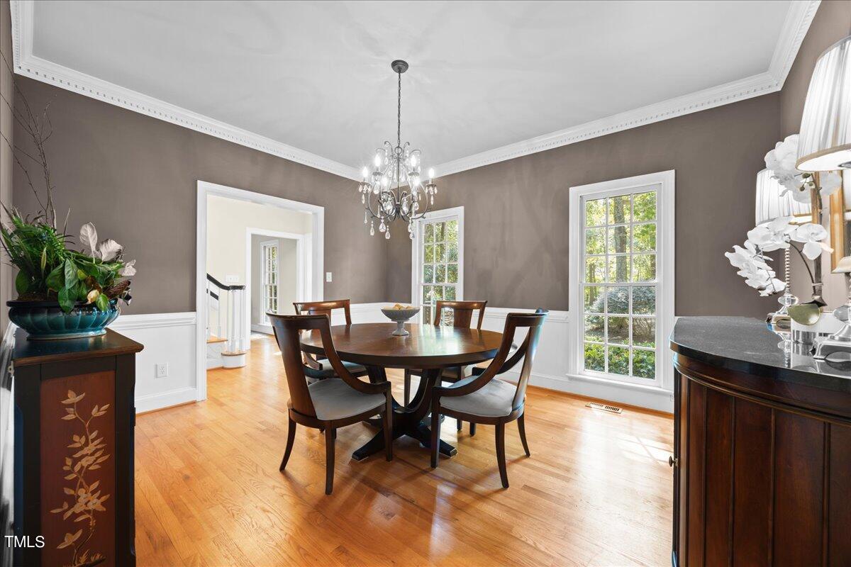 10036 Old Warden Road Raleigh, NC 27615 - Photo 9 of 42 a dining room with furniture potted plants and wooden floor