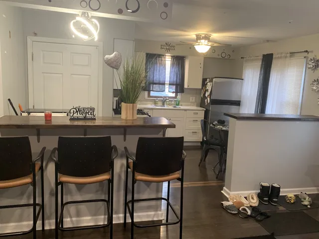 a kitchen with a table chairs refrigerator and microwave