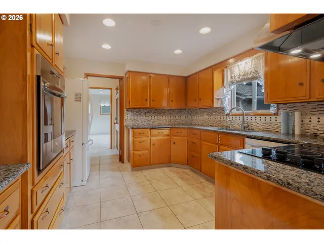 a kitchen with stainless steel appliances granite countertop a refrigerator and a stove