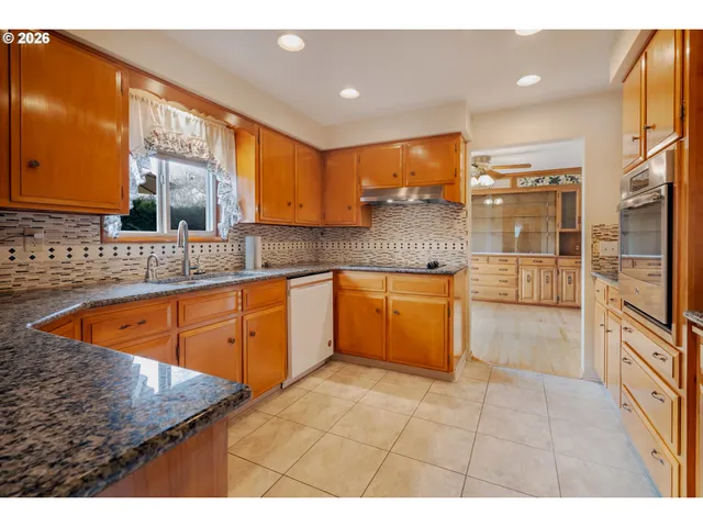 a kitchen with white cabinets and sink