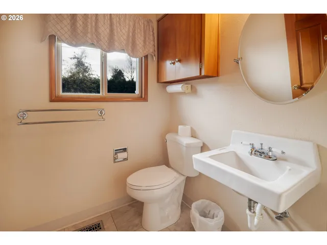 a view of an empty room with window and mirror