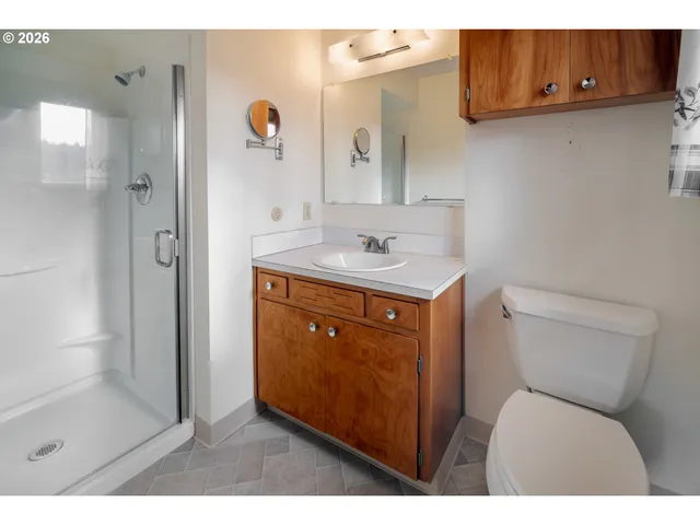 a bathroom with a sink shower and a mirror