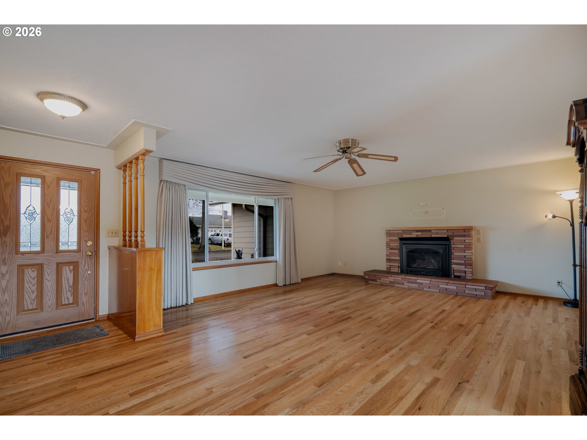 4290 Ivory Way Northeast Salem, OR 97305 - Photo 8 of 42 a view of an empty room with wooden floor fireplace and a window