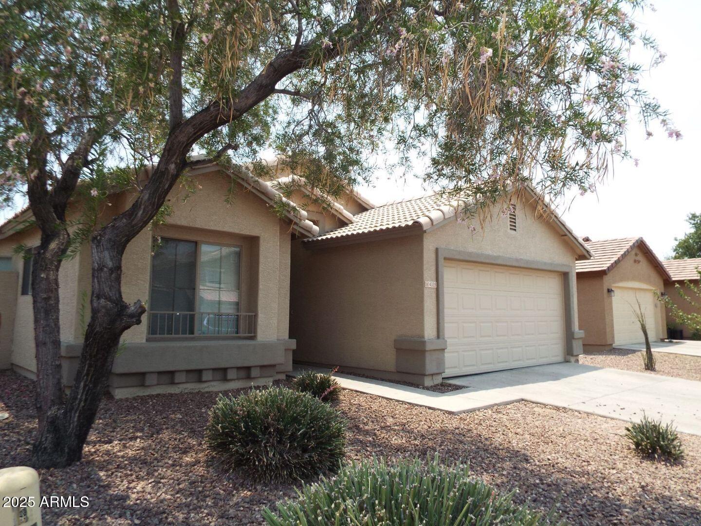 4335 West Carson Road Laveen, AZ 85339 - Photo 1 of 12 a front view of a house with a yard and garage