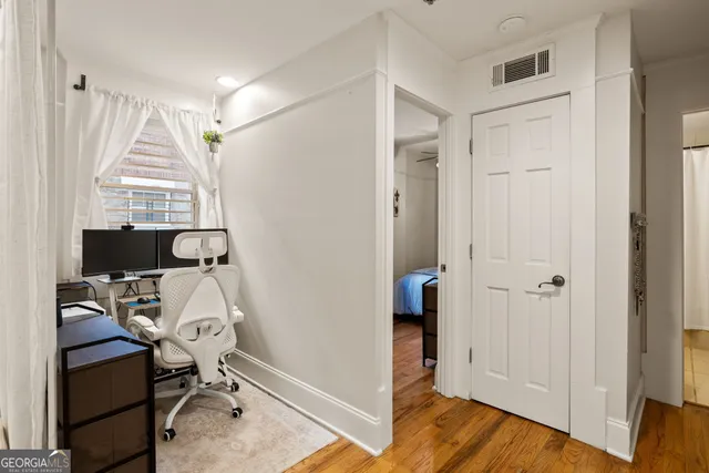 a view of a workspace with furniture and a window
