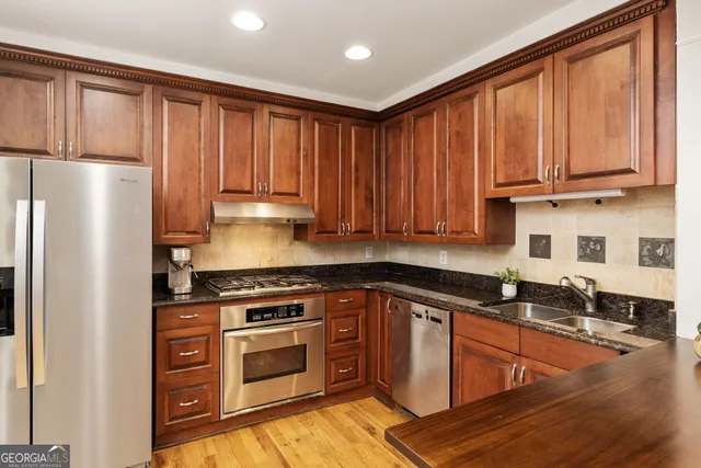 a kitchen with granite countertop wooden cabinets and a stove top oven