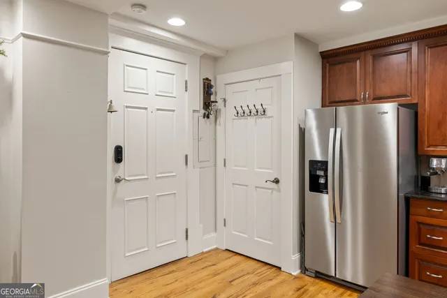 a view of a kitchen with refrigerator and wooden floor