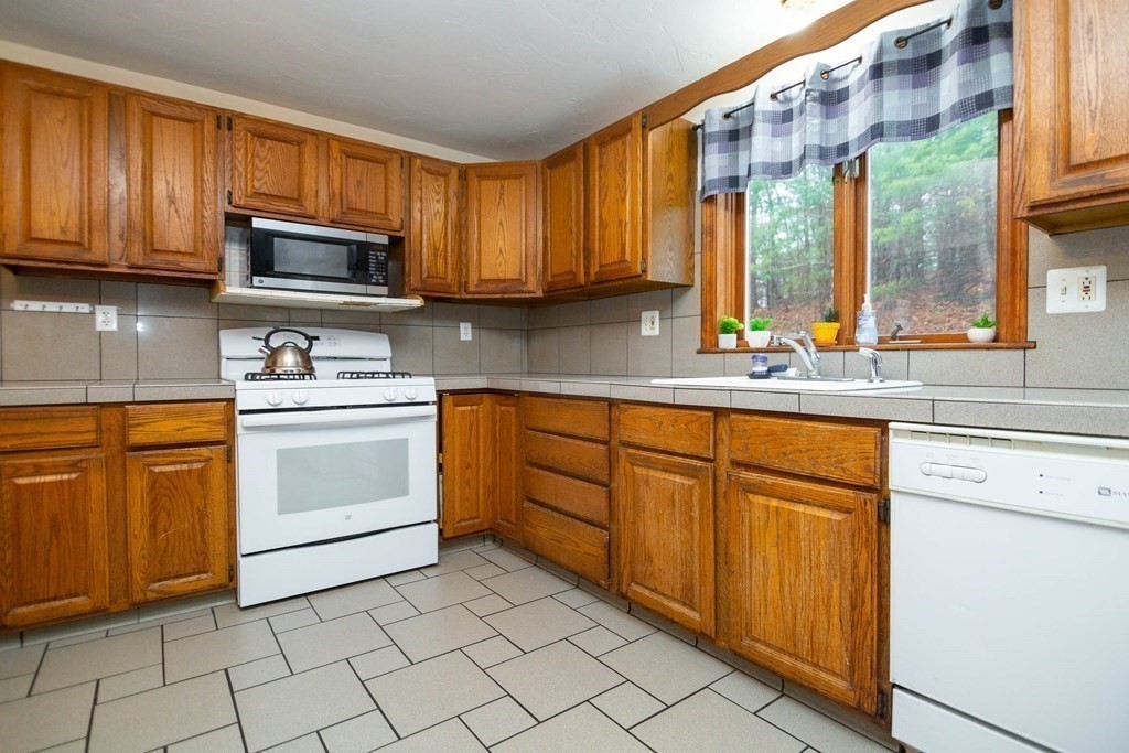 114 Leslie Road Rowley, MA 01969 - Photo 11 of 42 a kitchen with stainless steel appliances granite countertop a sink and cabinets