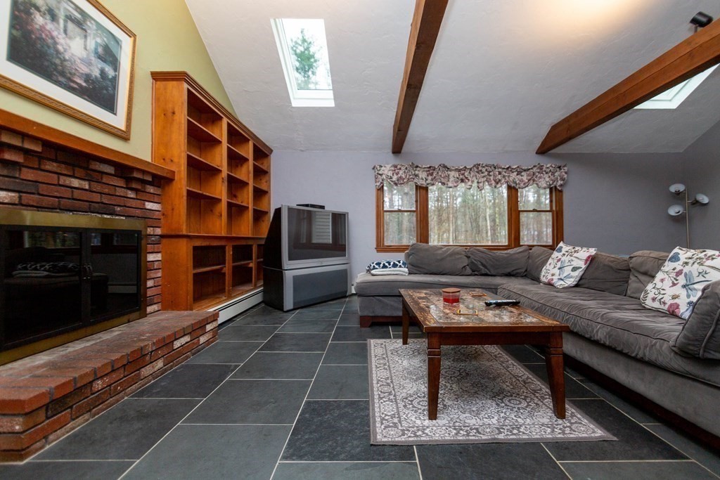 114 Leslie Road Rowley, MA 01969 - Photo 15 of 42 a living room with furniture a rug and a fireplace
