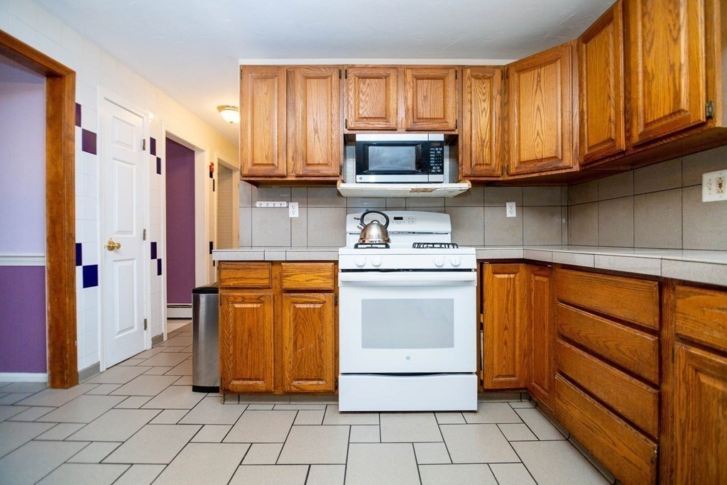 114 Leslie Road Rowley, MA 01969 - Photo 10 of 42 a kitchen with stainless steel appliances granite countertop a refrigerator and microwave