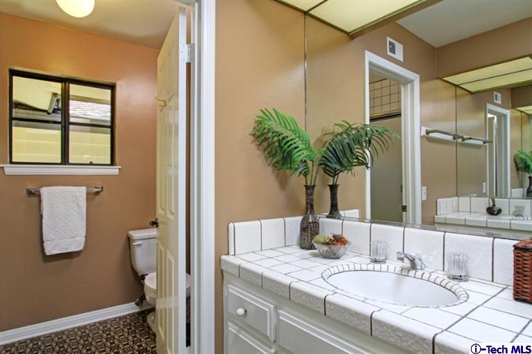 494 California Terrace Pasadena, CA 91105 - Photo 19 of 25 a bathroom with a granite countertop sink a mirror and a shower