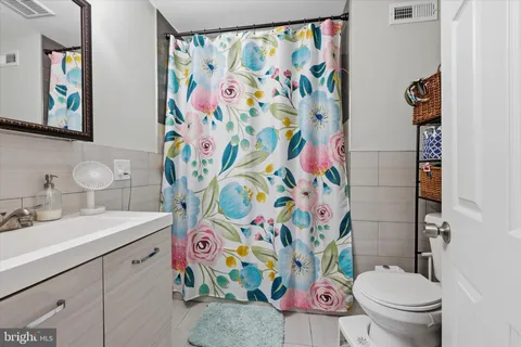 a bathroom with a sink a toilet and painting on the wall