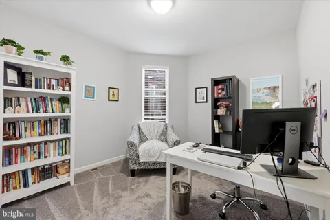 a living room with furniture and a book shelf
