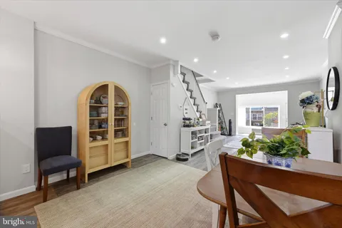 a living room with furniture windows and potted plants