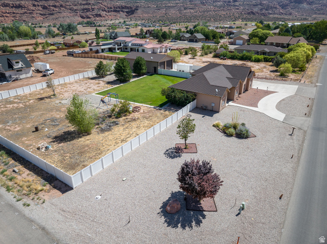 4635 East Sunny Acres Lane Moab, UT 84532 - Photo 6 of 56 Single-story residence featuring an attached garage, a paved driveway, and a gravel front yard with mature landscaping