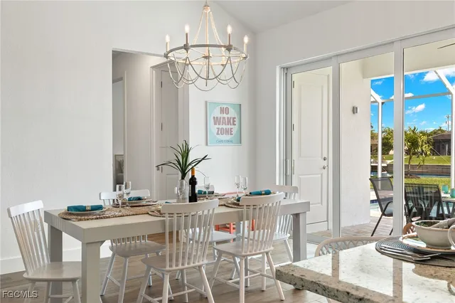 a view of a dining room with furniture a chandelier and wooden floor