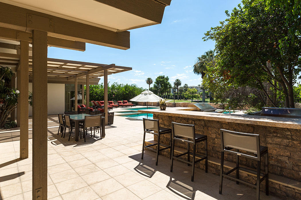 12 Avenida Andra Palm Desert, CA 92260 - Photo 8 of 42 a view of a patio with dining table and chairs under an umbrella with a barbeque