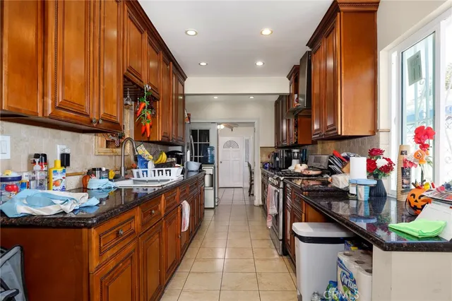 a kitchen with stainless steel appliances granite countertop a sink stove and cabinets