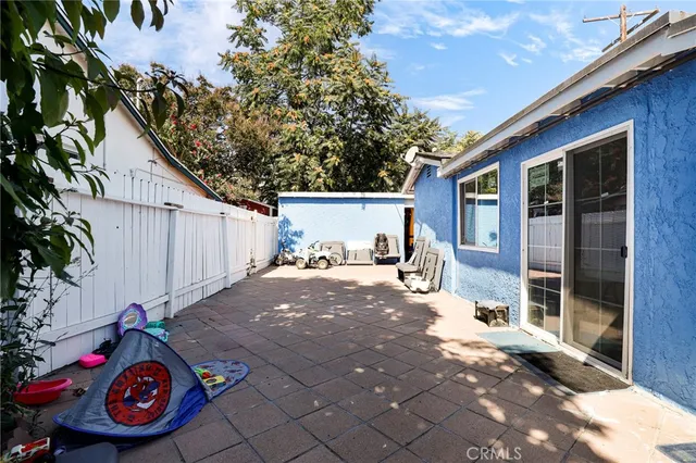 a view of a backyard with table and chairs and potted plants