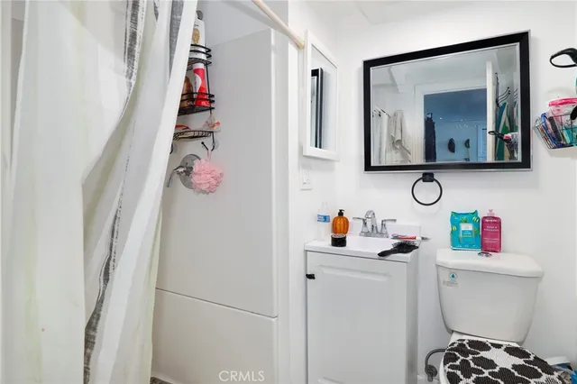 a bathroom with a sink vanity mirror and toilet